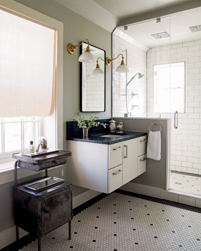 One of a pair of his-and-hers floating vanities in a master bath is shown here with vintage-style hex floors. White glass lamps beside the mirrors provide face-flattering light, and flush mount square rain shower heads lend a spa-like feel.