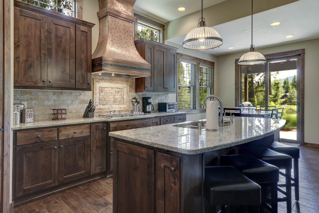 Luxury dark wood rich kitchen interior with copper stove hood an